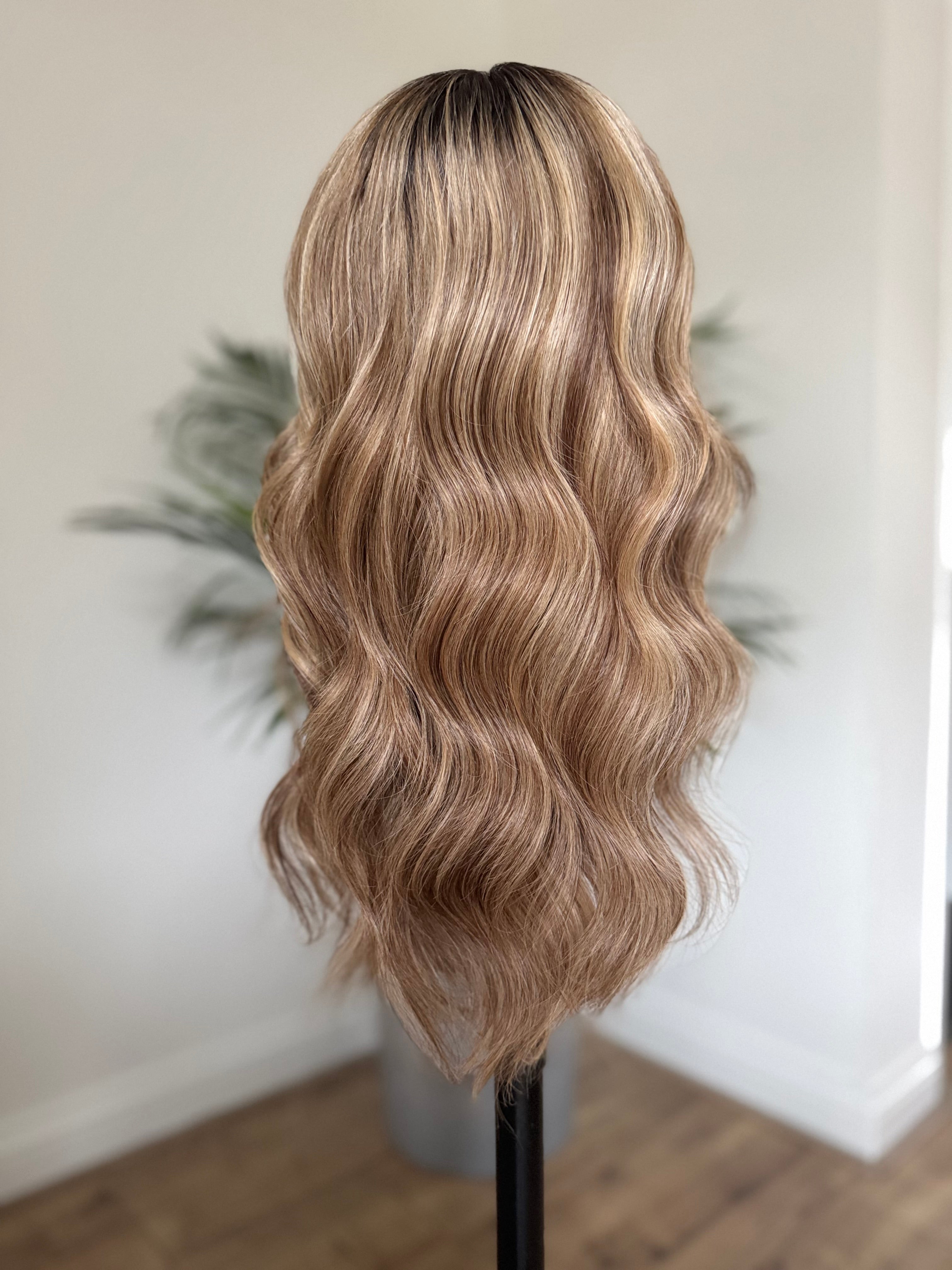 Back view of long brown blonde balayage human hair wig with soft waves